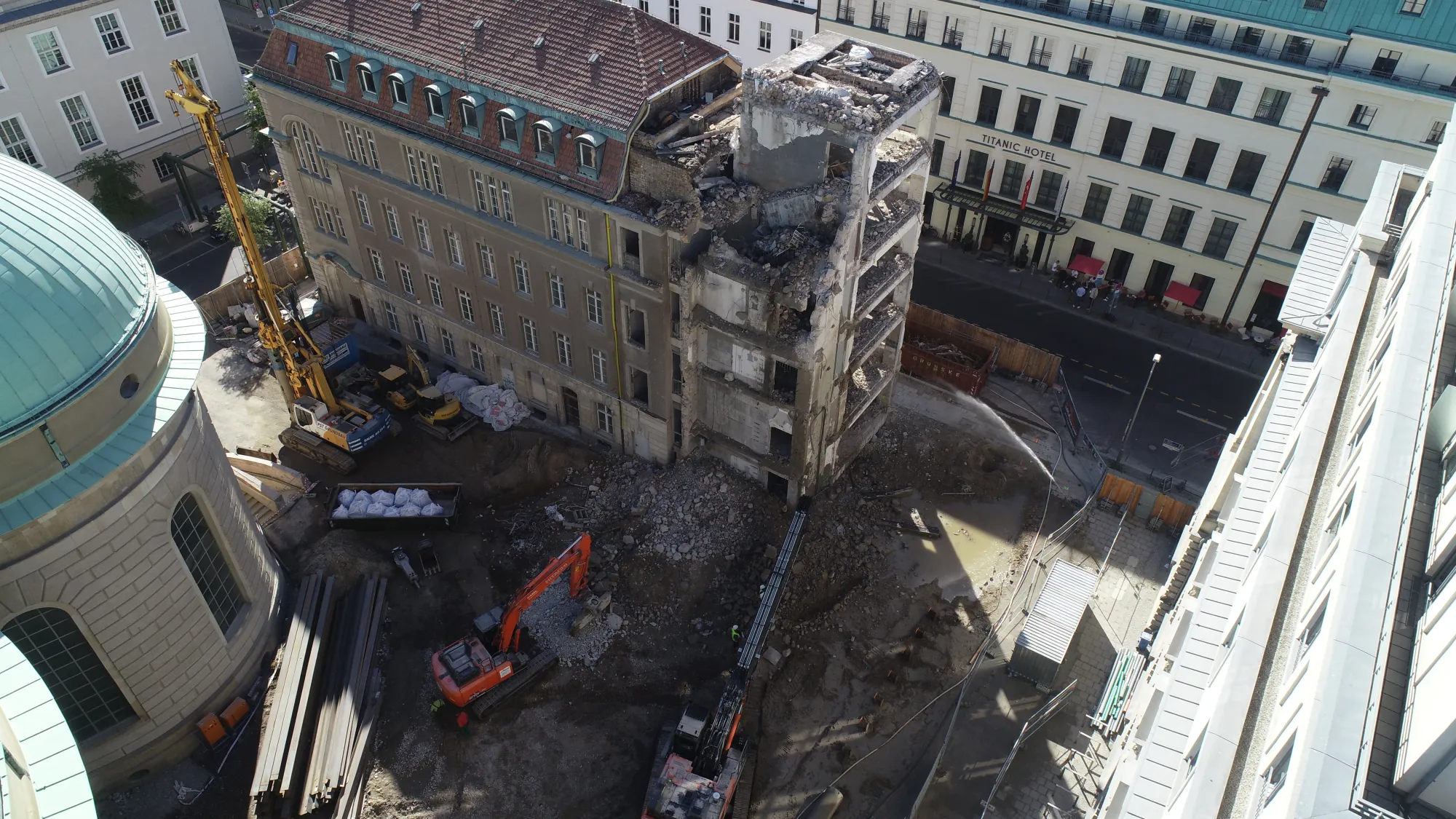 Luftaufnahme eines Altbau-Rückbaus in der Berliner Innenstadt mit Longfront-Bagger und Mobilkran