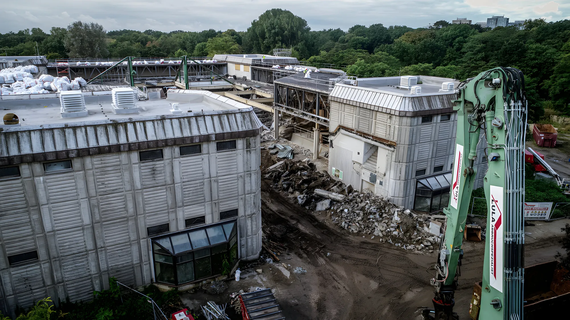 Longfront-Bagger der Lula Bau GmbH beim Industrieabbruch bei Tageslicht, Luftaufnahme