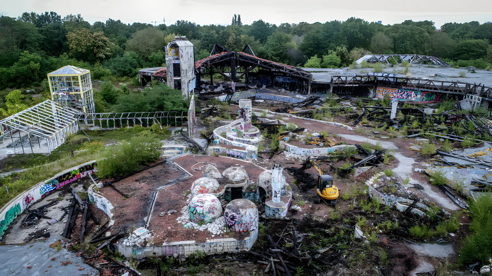 Rückbau eines verlassenen, überwucherten Gebäudekomplexes im Grünen, Luftbild